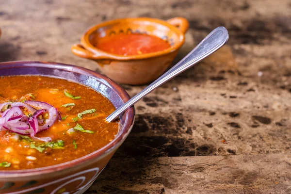 Birria stew topping with red onion and cilantro ready to eat