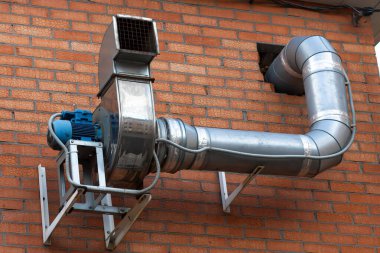 Binanın dış motorunun egzoz sistemi yapısı, dikey tuğla duvara monte edilmiş..