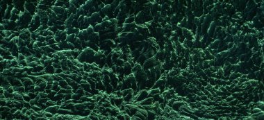 Beton duvar soyutlama arka planı. El oyması desen ve koyu nane ışığıyla güzelce aydınlatılmış..