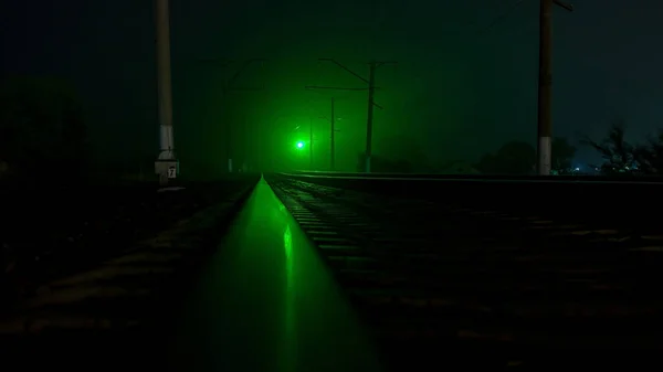 夜晚空荡荡的铁路绿色交通灯 一阵大风摇曳着树木 — 图库照片