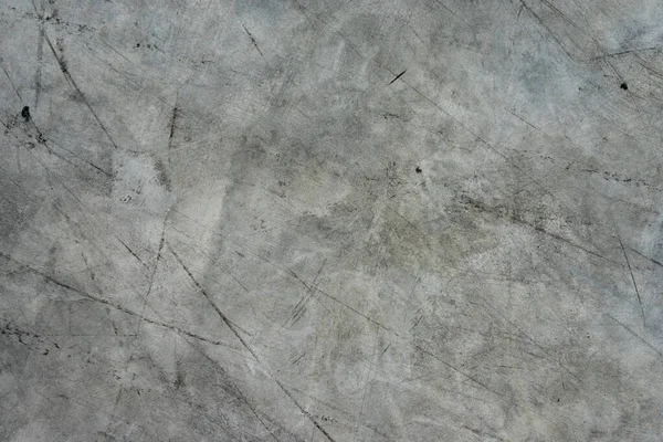 The background of the gray concrete floor is exhausted by black stripes.