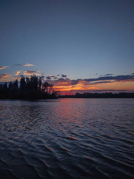 Nehir boyunca gün batımı gezisi. Deniz kenarında güzel bir gün batımı. Suda küçük dalgalar.