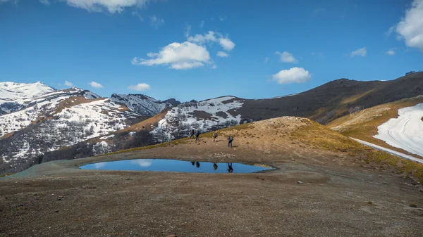 Grupa Turystów Przejeżdża Przez Mały Zbiornik Wodny Górach Wędrówki Góry — Zdjęcie stockowe