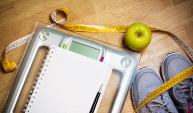 Spor ayakkabı, santimetre, yeşil elma, defter, ölçek. Kilo verme, sağlıklı yaşam konsepti