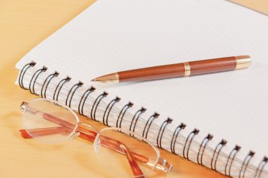 Kalem, defter ve gözlük. Seçici odak