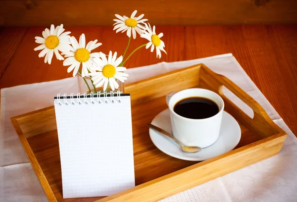 Кофе и ромашки на деревянном столе. Селективный акцент на ромашки — стоковое фото