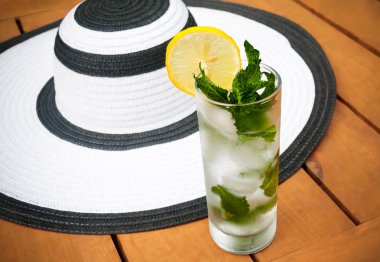 Bardak su buz ve nane ve yaz şapka ile. Cam üzerinde seçici odak