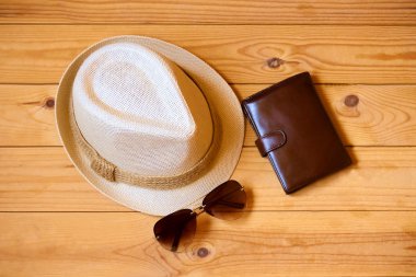 Şapka, m-cüzdan ve ahşap arka plan üzerinde güneş gözlüğü. Gevşeme ya da tatil kavramı
