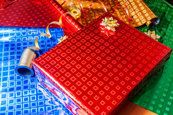 Gift wrapped in red paper with golden ribbon — Stock Photo, Image