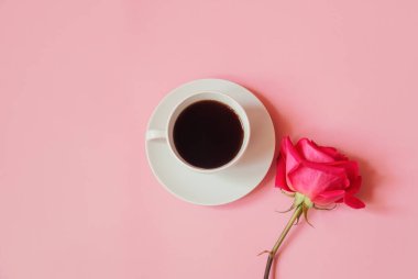 Bir fincan kahve ve pembe gül. Üst görünüm, alanı kopyala.