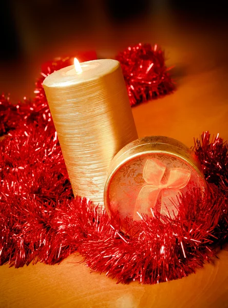 Candle and gift box with red tinsel — Stock Photo, Image