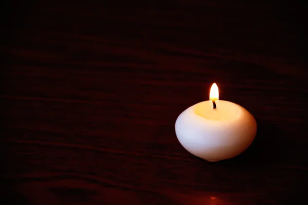 Vela única em uma mesa de madeira escura. Fechar tiro com selecti — Fotografia de Stock