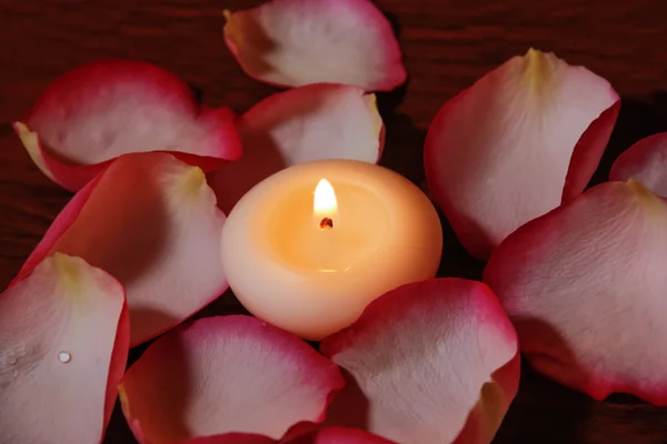 Kaars en roze bloemblaadjes. Selectieve aandacht op kaars — Stockfoto