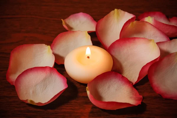 Candle and rose petals. Selective focus on candle — Stock Photo, Image