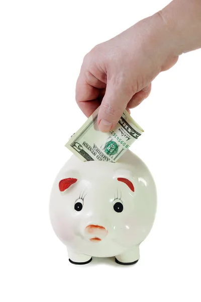 Female hand putting five-dollar bill into a piggy bank — Stock Photo, Image