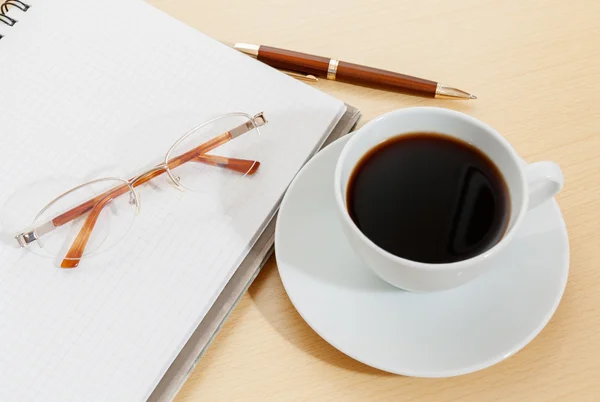 Image of notebook, coffee cup, pen and glasses Stock Photo