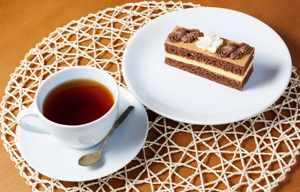 木製のテーブルにお茶と甘いケーキのカップ — ストック写真