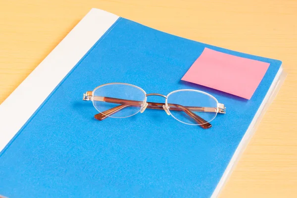 Blå office-mappen och glasögon — Stockfoto