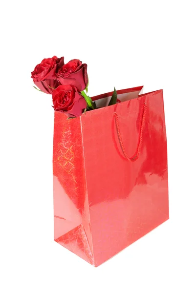 Drie rode rozen in rode certificaat en cadeauzakje op witte achtergrond — Stockfoto