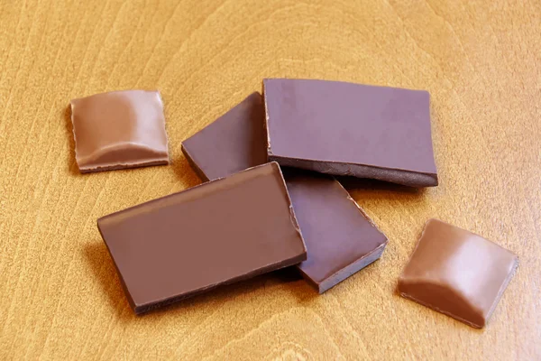 Groep chocoladestukjes op houten achtergrond. Selectieve aandacht — Stockfoto