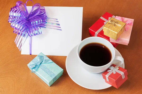 Leere Grußkarte mit Schleife, farbigen Geschenkboxen und weißem cof — Stockfoto