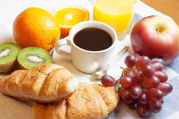 Śniadanie z kawa, sok pomarańczowy, rogaliki i owoce — Zdjęcie stockowe