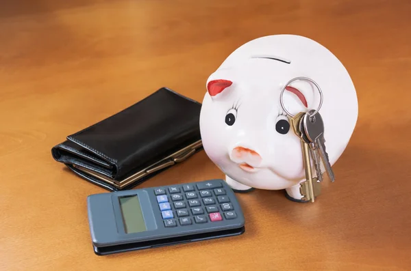 Piggy Bank, calculator, keys  and purse on wood table — Stock Photo, Image