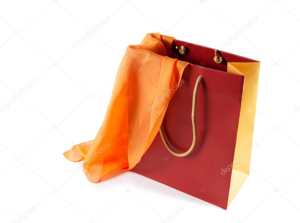 Red-orange gift bag and   orange silk scarf isolated on white