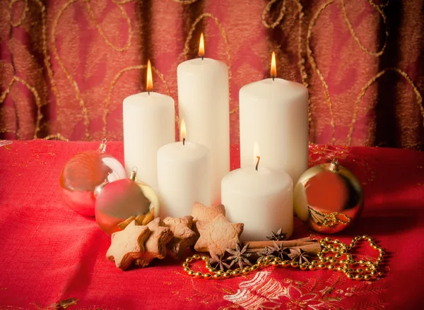 Свечи с рождественскими шариками, печеньем и специями — стоковое фото