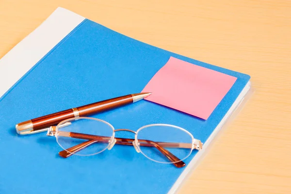 Pasta azul do escritório, óculos e caneta. Foco seletivo — Fotografia de Stock