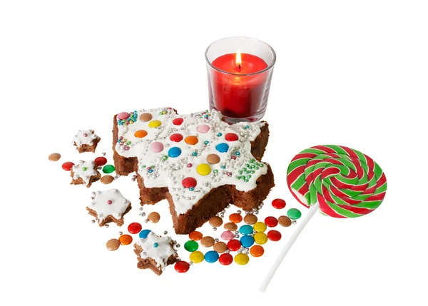 Domácí dort ve tvaru vánoční strom, malé sušenky, bonbony a svíčka — Stock fotografie