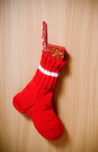 Winter warm sock with christmas gift on wooden background — Stock Photo, Image