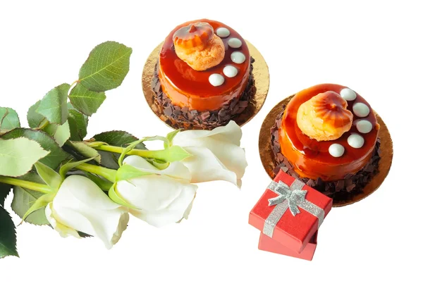 Kek, beyaz gül ve beyaz zemin üzerine kırmızı hediye kutusu