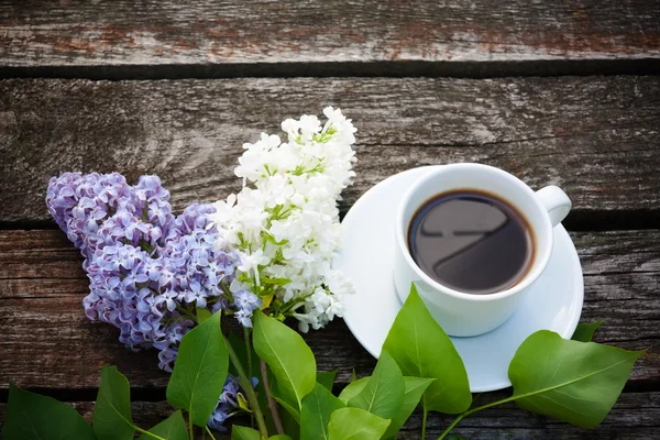 Taza de café y flores de colores lila sobre fondo de madera —  Fotos de Stock