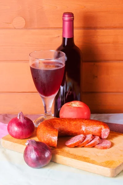 Vinho em garrafa e vidro e salsicha em fundo de madeira — Fotografia de Stock