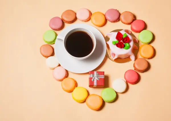 Franse bitterkoekjes, kopje koffie, doos van de gift en taart — Stockfoto