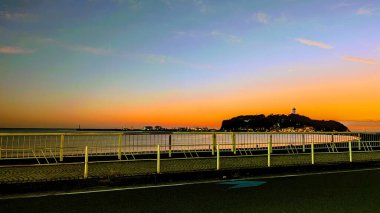 Enoshima adasıyla şehrin üzerinde güzel bir gün batımı.