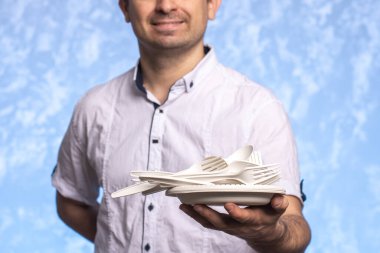 Biyolojik ayrıştırılabilir mısır nişastası çatalları, kaşıklar, tabaklar ve bardaklar erkeklerin elinde. Yakın plan. Çevre dostu kavram. Tek kullanımlık çatal bıçak takımı