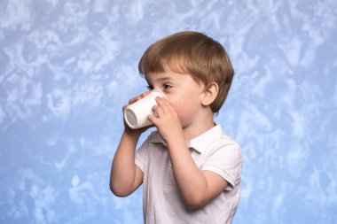 Küçük çocuk tek kullanımlık mısır nişastasından su içiyor. Ekolojik olarak temiz. Plastiğin yerini modern biyolojik çözünebilir malzemeler alıyor. Avrupa görünümlü çocuk yakın çekim