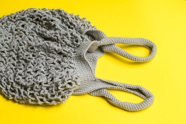 Sarı arka planda gri örgü çantalı ip torbası var. Düz çizgi. Çevre dostu kavram sıfır atık