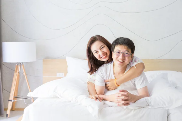 Ázsiai férj és feleség, mosolygó, fehér ágy — Stock Fotó