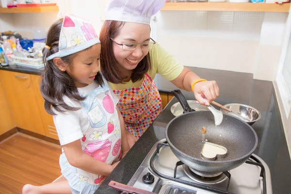 Asiatische Mutter und Tochter genießen Herstellung Pfannkuchen in Küche zu Hause — Stockfoto