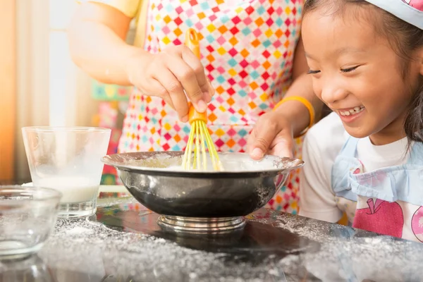 Asian mother and daughter enjoy making pancake