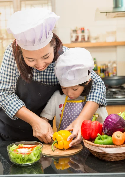 Asian mother teaching daughter making salad in kitchen,Cooking  concept of happy asian little girl and mother making salad