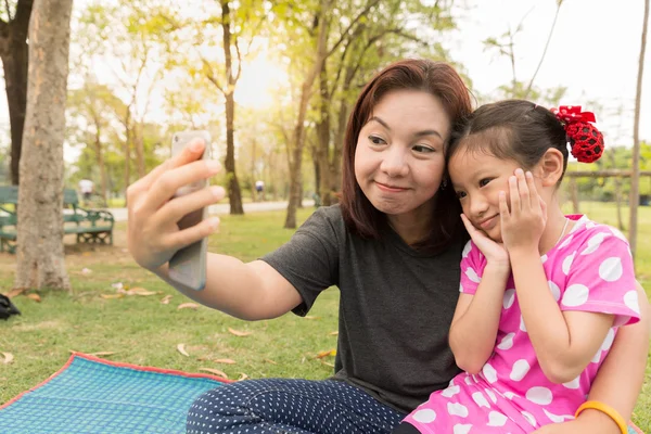 Mamma lär dotter tar selfie foto av smart telefon — Stockfoto