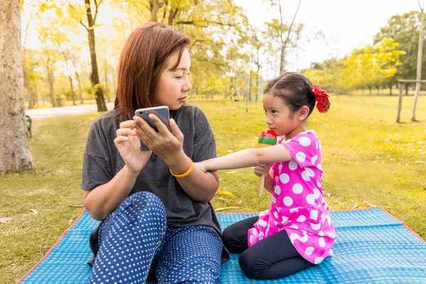 Mère jouant téléphone intelligent avec insouciance sa fille — Photo