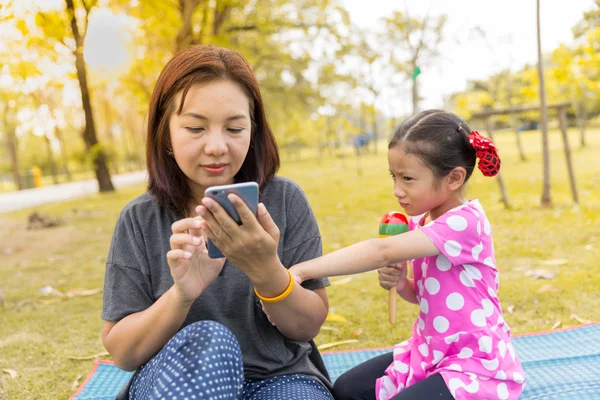 Moeder spelen slimme telefoon met slordig haar dochter — Stockfoto