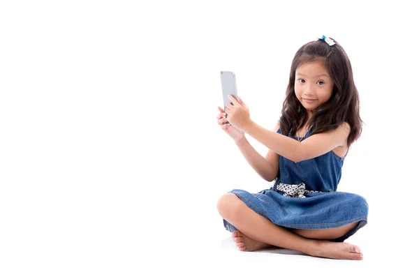 Pequeña chica asiática posando con teléfono inteligente aislado sobre fondo blanco — Foto de Stock