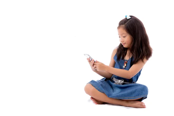 Pequeña chica asiática posando con teléfono inteligente aislado sobre fondo blanco — Foto de Stock