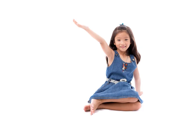 Pieni aasialainen tyttö poseeraa venyttää käsi ylös eristää valkoisella taustalla — kuvapankkivalokuva